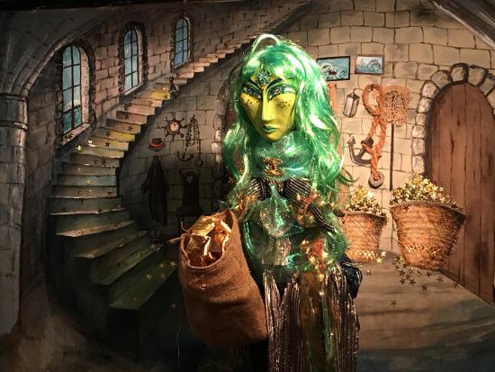 La sirène Gwendoline, aux cheveux et visage verts, à l'intérieur du phare, avec des sacs pleins d'étoiles