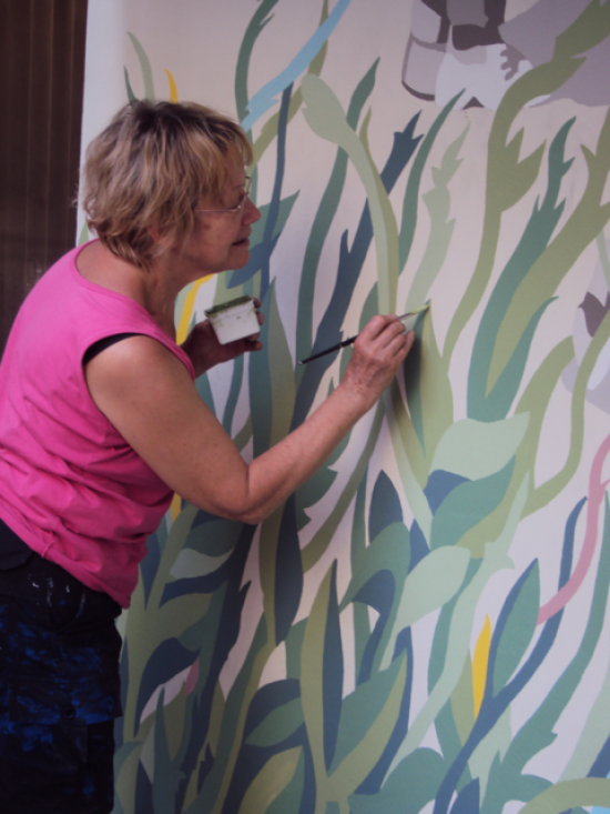 Marie-Jeanne Plaar en train de peindre la fresque