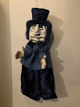 Vieil homme aux cheveux noir, vêtu de noir, avec un chapeau noir