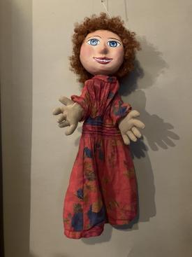 Fillette brune aux yeux bleus, vêtue d'un habit rouge à motifs