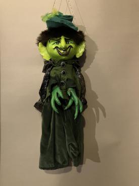 Diable à la tête et aux mains vertes, vêtu d'un costume vert et d'une cape grise