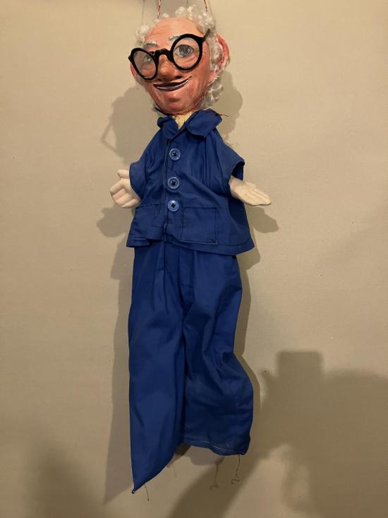 Vieil homme à lunettes, vêtu d'un pantalon et d'une veste bleus