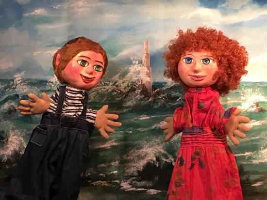 Toinette et Titouan sur la plage, devant la mer déchaînée, phare au loin