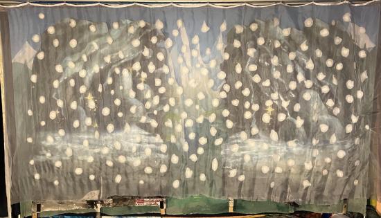 Forêt de sapins, montagnes enneigées, précipice, deux rochers au premier plan, neige qui tombe